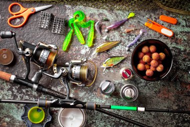 Balıkçılık çubuklar ve spinnings tablosundaki eski arka plan üzerinde balıkçılık için aksesuarlar ile kompozisyon