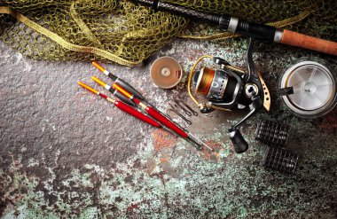 Balıkçılık çubuklar ve spinnings tablosundaki eski arka plan üzerinde balıkçılık için aksesuarlar ile kompozisyon