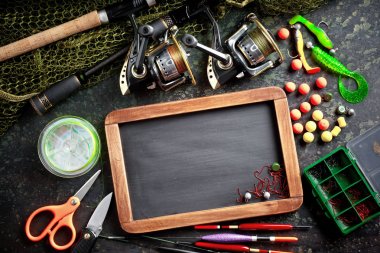 Balıkçılık çubuklar ve spinnings tablosundaki eski arka plan üzerinde balıkçılık için aksesuarlar ile kompozisyon