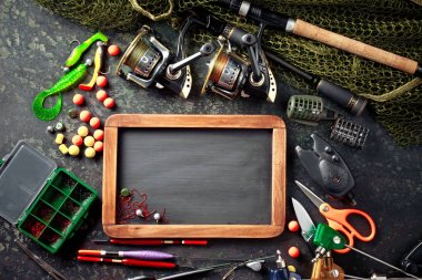 Balıkçılık çubuklar ve spinnings tablosundaki eski arka plan üzerinde balıkçılık için aksesuarlar ile kompozisyon