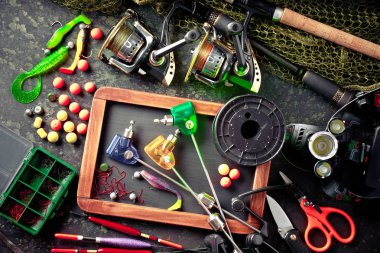 Balıkçılık çubuklar ve spinnings tablosundaki eski arka plan üzerinde balıkçılık için aksesuarlar ile kompozisyon