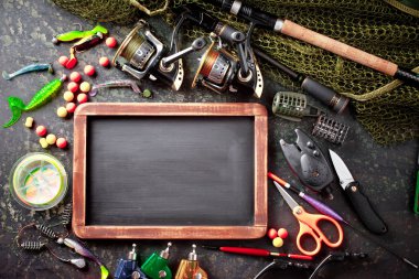 Balıkçılık çubuklar ve spinnings tablosundaki eski arka plan üzerinde balıkçılık için aksesuarlar ile kompozisyon