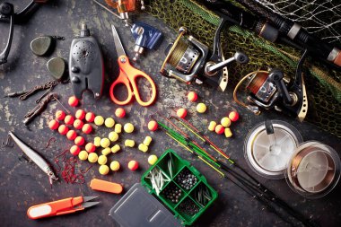 Balıkçılık çubuklar ve spinnings tablosundaki eski arka plan üzerinde balıkçılık için aksesuarlar ile kompozisyon