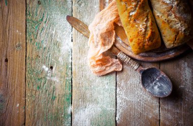 Ekmek ve hamur işleri eski bir arka plan üzerinde mutfak aksesuarları ile bir kompozisyon içinde