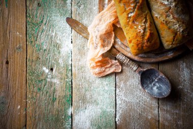 Ekmek ve hamur işleri eski bir arka plan üzerinde mutfak aksesuarları ile bir kompozisyon içinde