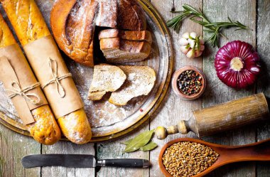 Ekmek ve hamur işleri eski bir arka plan üzerinde mutfak aksesuarları ile bir kompozisyon içinde