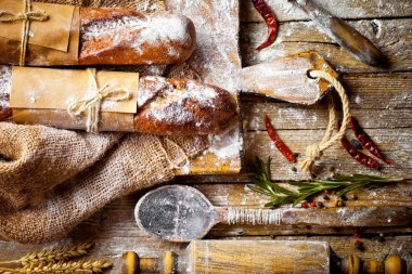 Ekmek ve hamur işleri eski bir arka plan üzerinde mutfak aksesuarları ile bir kompozisyon içinde