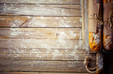 Ekmek ve hamur işleri eski bir arka plan üzerinde mutfak aksesuarları ile bir kompozisyon içinde