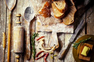 Ekmek ve hamur işleri eski bir arka plan üzerinde mutfak aksesuarları ile bir kompozisyon içinde