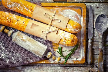 Ekmek ve hamur işleri eski bir arka plan üzerinde mutfak aksesuarları ile bir kompozisyon içinde