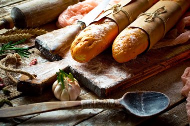 Ekmek ve hamur işleri eski bir arka plan üzerinde mutfak aksesuarları ile bir kompozisyon içinde