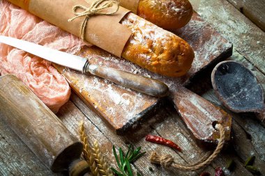 Ekmek ve hamur işleri eski bir arka plan üzerinde mutfak aksesuarları ile bir kompozisyon içinde