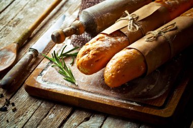 Ekmek ve hamur işleri eski bir arka plan üzerinde mutfak aksesuarları ile bir kompozisyon içinde