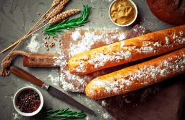 Ekmek ve hamur işleri eski bir arka plan üzerinde mutfak aksesuarları ile bir kompozisyon içinde