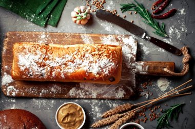 Ekmek ve hamur işleri eski bir arka plan üzerinde mutfak aksesuarları ile bir kompozisyon içinde