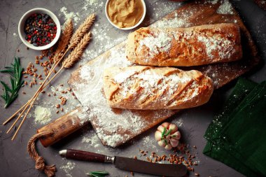 Ekmek ve hamur işleri eski bir arka plan üzerinde mutfak aksesuarları ile bir kompozisyon içinde