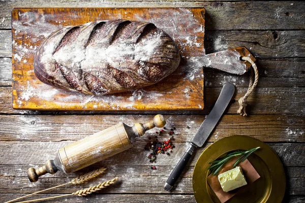 Bread and pastries in a composition with kitchen accessories on an old background