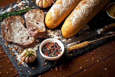 Ekmek ve hamur işleri eski bir arka plan üzerinde mutfak aksesuarları ile bir kompozisyon içinde