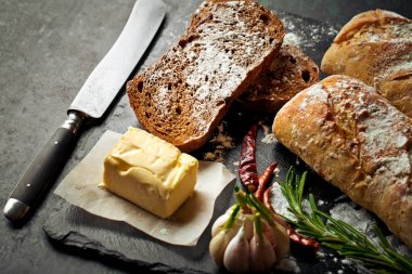 Ekmek ve hamur işleri eski bir arka plan üzerinde mutfak aksesuarları ile bir kompozisyon içinde