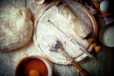 Mutfak aksesuarları ile bir kompozisyon içinde eski bir arka plan üzerinde un ile hamur