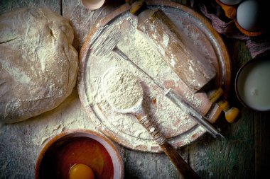 Mutfak aksesuarları ile bir kompozisyon içinde eski bir arka plan üzerinde un ile hamur