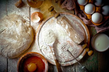 Mutfak aksesuarları ile bir kompozisyon içinde eski bir arka plan üzerinde un ile hamur
