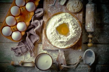 Mutfak aksesuarları ile bir kompozisyon içinde eski bir arka plan üzerinde un ile hamur