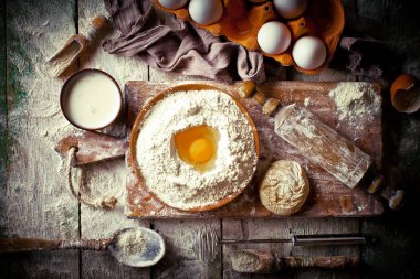 Mutfak aksesuarları ile bir kompozisyon içinde eski bir arka plan üzerinde un ile hamur