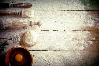 Mutfak aksesuarları ile bir kompozisyon içinde eski bir arka plan üzerinde un ile hamur