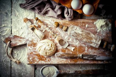 Mutfak aksesuarları ile bir kompozisyon içinde eski bir arka plan üzerinde un ile hamur