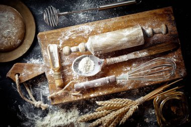 Mutfak aksesuarları ile bir kompozisyon içinde eski bir arka plan üzerinde un ile hamur