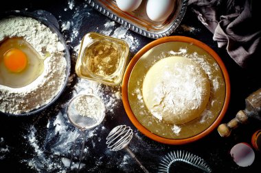 Mutfak aksesuarları ile bir kompozisyon içinde eski bir arka plan üzerinde un ile hamur