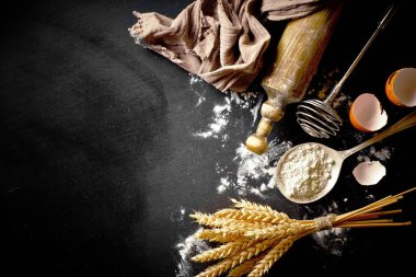 Mutfak aksesuarları ile bir kompozisyon içinde eski bir arka plan üzerinde un ile hamur