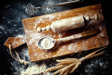 Mutfak aksesuarları ile bir kompozisyon içinde eski bir arka plan üzerinde un ile hamur