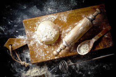 Mutfak aksesuarları ile bir kompozisyon içinde eski bir arka plan üzerinde un ile hamur