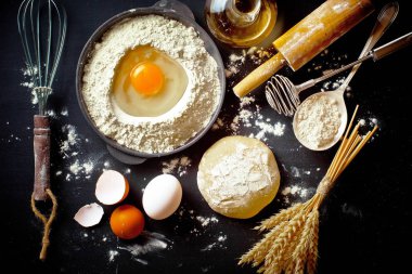 Mutfak aksesuarları ile bir kompozisyon içinde eski bir arka plan üzerinde un ile hamur