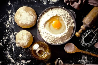 Mutfak aksesuarları ile bir kompozisyon içinde eski bir arka plan üzerinde un ile hamur