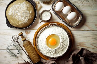 Mutfak aksesuarları ile bir kompozisyon içinde eski bir arka plan üzerinde un ile hamur