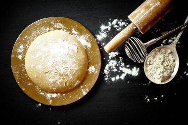 Mutfak aksesuarları ile bir kompozisyon içinde eski bir arka plan üzerinde un ile hamur