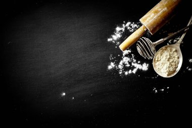 Mutfak aksesuarları ile bir kompozisyon içinde eski bir arka plan üzerinde un ile hamur