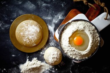 Mutfak aksesuarları ile bir kompozisyon içinde eski bir arka plan üzerinde un ile hamur