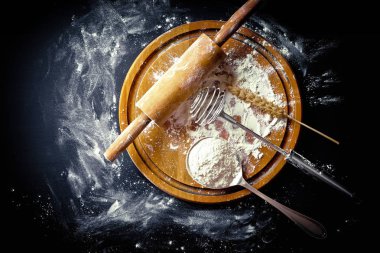 Mutfak aksesuarları ile bir kompozisyon içinde eski bir arka plan üzerinde un ile hamur