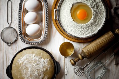 Mutfak aksesuarları ile bir kompozisyon içinde eski bir arka plan üzerinde un ile hamur