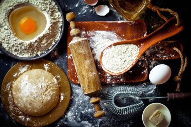 Mutfak aksesuarları ile bir kompozisyon içinde eski bir arka plan üzerinde un ile hamur