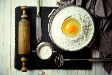 Mutfak aksesuarları ile bir kompozisyon içinde eski bir arka plan üzerinde un ile hamur