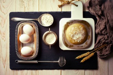 Mutfak aksesuarları ile bir kompozisyon içinde eski bir arka plan üzerinde un ile hamur