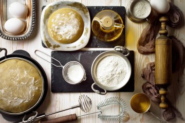 Mutfak aksesuarları ile bir kompozisyon içinde eski bir arka plan üzerinde un ile hamur