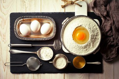 Mutfak aksesuarları ile bir kompozisyon içinde eski bir arka plan üzerinde un ile hamur