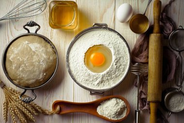 Mutfak aksesuarları ile bir kompozisyon içinde eski bir arka plan üzerinde un ile hamur