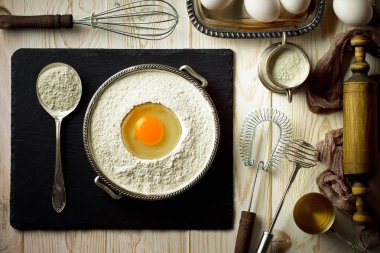 Mutfak aksesuarları ile bir kompozisyon içinde eski bir arka plan üzerinde un ile hamur